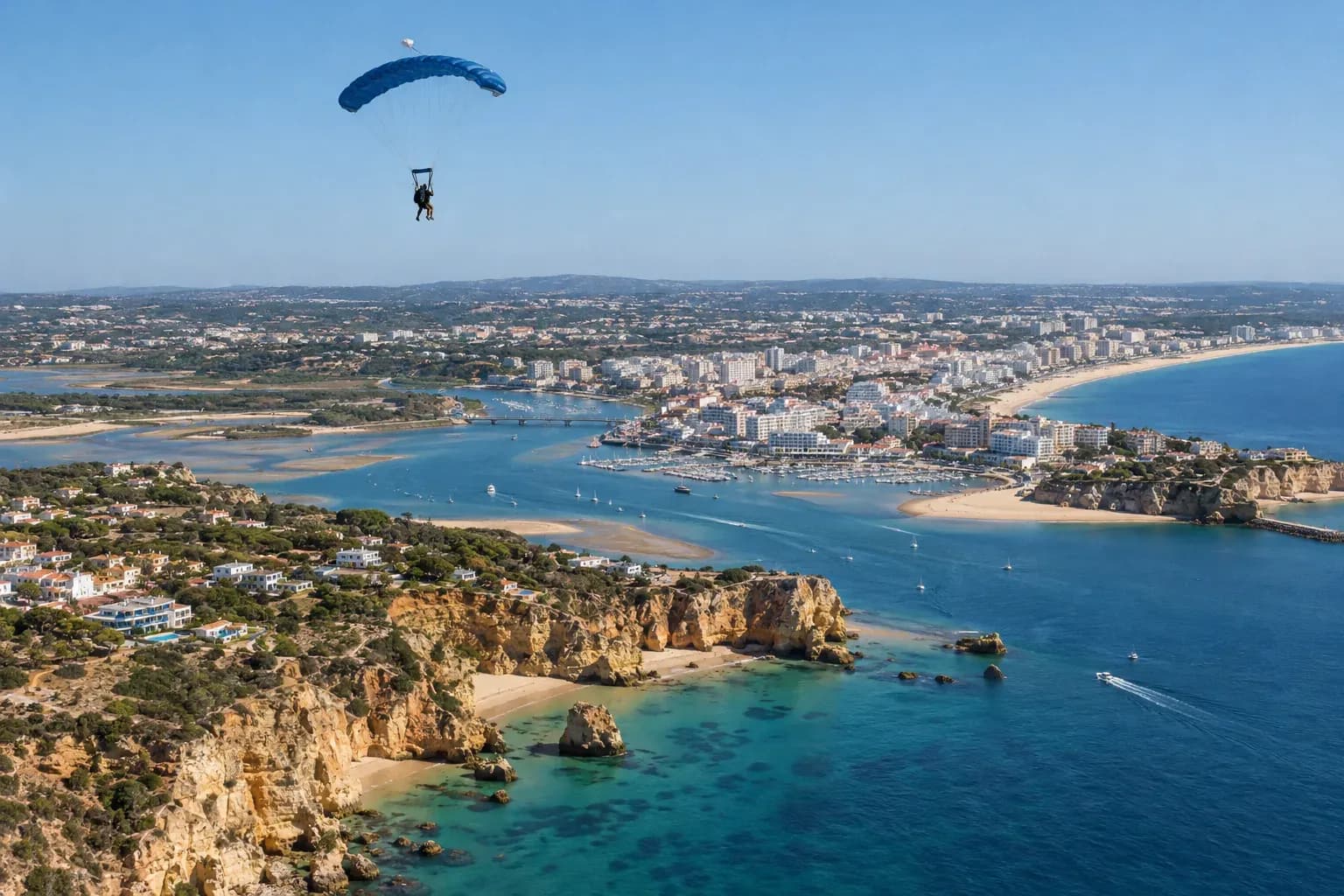 A tandem parachute high above the Alvor estuary and the beaches of Portimão