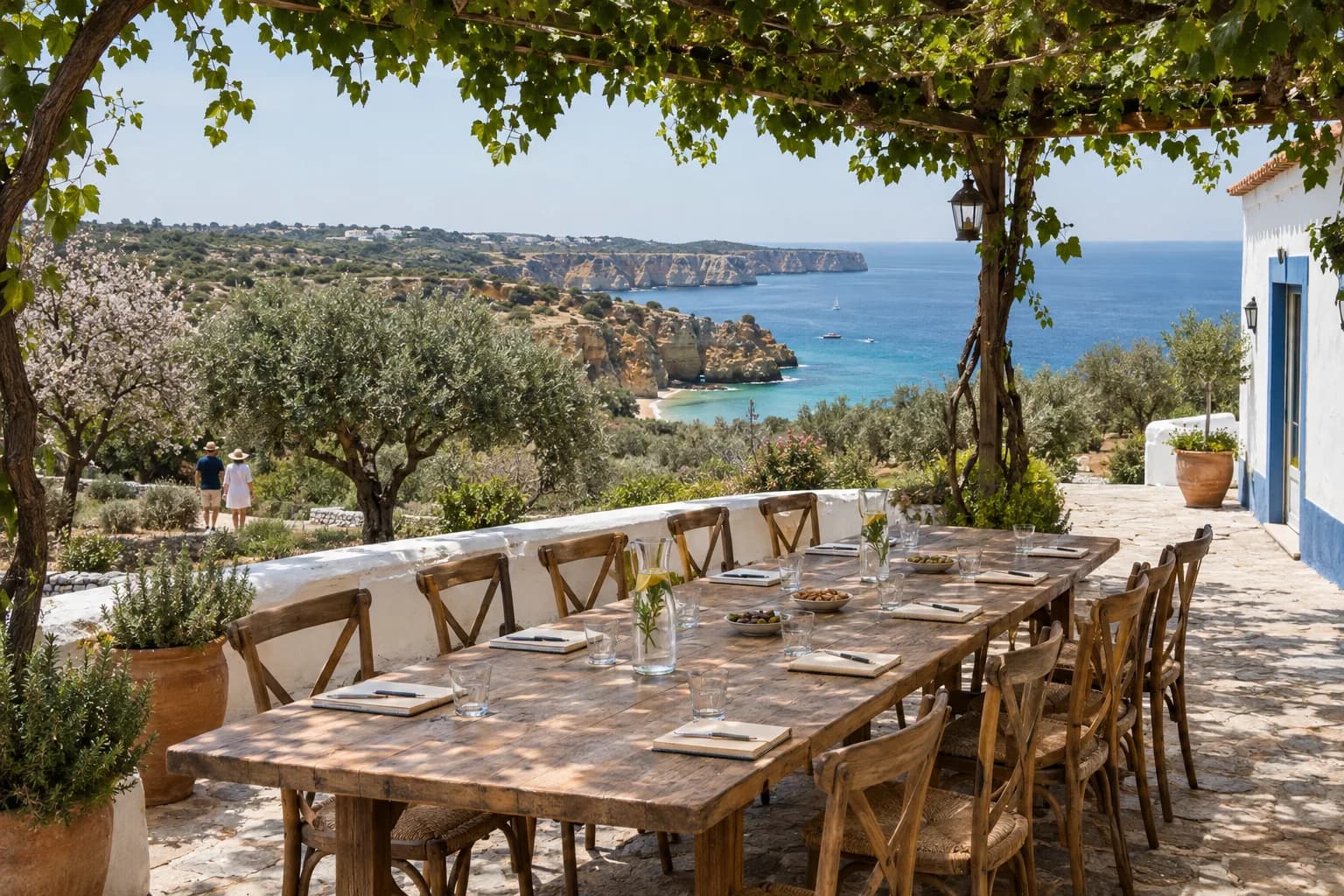 A long wooden table under a vine pergola set with notebooks for twelve